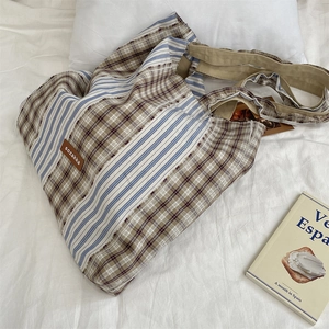 Detail of vintage patchwork canvas tote bag featuring plaid and striped textile patterns