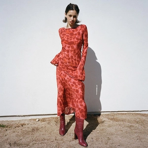 Detail of red floral maxi dress showing long sleeves and flowy chiffon material with boots