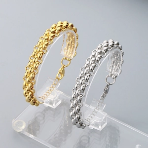 Dettaglio di bracciali a catena intrecciata con finiture in oro 18K e argento lucido