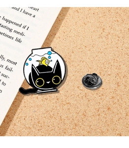 Detailed close-up of a cartoon black cat in fishbowl enamel pin on cork background