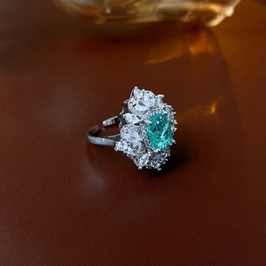 Dettaglio macro di un anello regolabile in argento con zircone verde taglio cushion