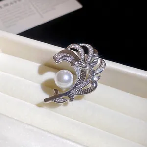Elegante spilla a piuma argentata con perla bianca e cristalli lucenti in una scatola