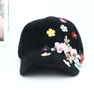 Détails des fleurs 3D colorées et des perles sur une casquette de baseball noire en peluche