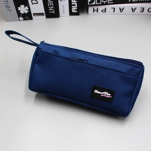 Detail of navy blue large capacity stationery bag with hand strap and woven brand label