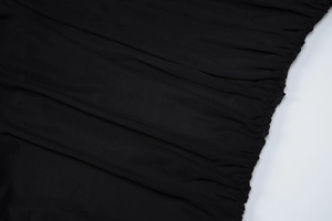 Close-up of black mesh fabric showing elegant pleats and detailed stitching craftsmanship