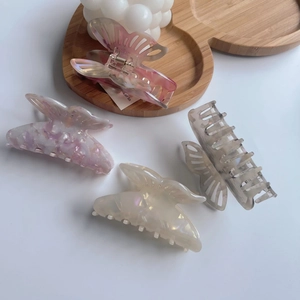 Detail of four acetate butterfly hair claws in marble, floral and pearlescent finishes