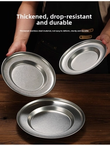 Close-up of a person holding a thick stainless steel deep plate over a wooden table