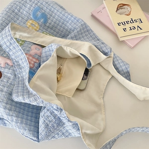 Detail of blue checkered tote bag interior with inner zipper pocket and phone storage
