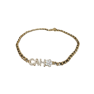 Golden chain choker with white camellia flower and pearl-inlaid letters CAH charms