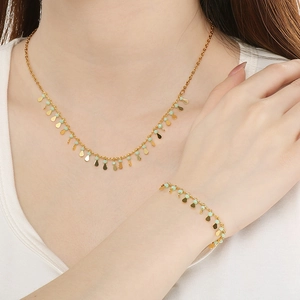 Golden drop necklace and bracelet set with mint green beads on female model