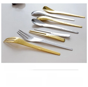 Close-up of hammered texture on stainless steel spoons and forks in gold and silver