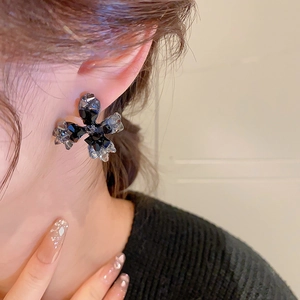 Détail de boucles d'oreilles fleur en cristal noir portées au style rétro de luxe