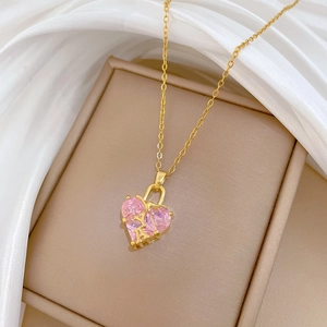 Détail macro d'un collier cœur doré orné de cristaux roses sur de la soie blanche
