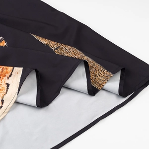 Close-up of tropical wing pattern print on black hem with detailed stitching