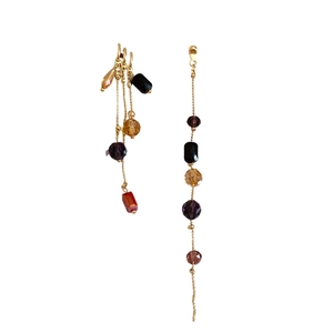 Asymmetric gold tassel earrings with colorful glass crystals on a clean white background