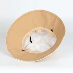 Détail de l'intérieur du chapeau beige avec cordon coupe-vent noir et étiquette de marque