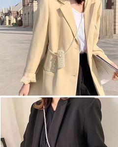 Detailed look at handmade white pearl woven mini bag styled on beige and black blazers