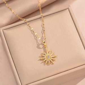 Close-up of golden sunburst star pendant necklace with crystals on a jewelry box