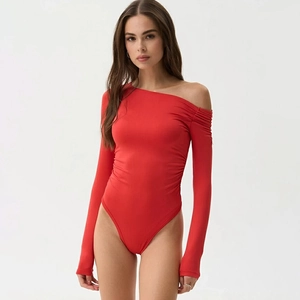 Gros plan sur un body rouge à manches longues avec coupe à l'épaule et fronces chic