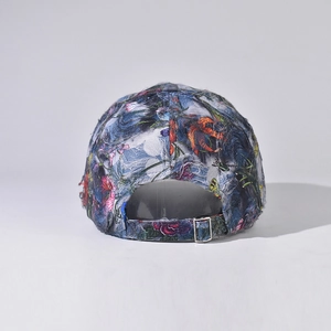 Detail view of denim floral baseball cap showing metal adjustment buckle and distressed texture