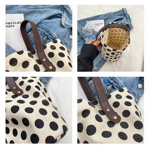 Detailed views of polka dot canvas bucket bag with leather handles and gold rivets