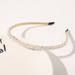 Detail shot of the golden pearl headband showing elegant alternating bead sizes on a slim wire