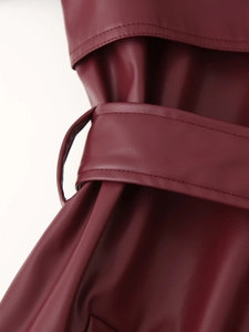 Vue détaillée de la texture du cuir PU bordeaux et de la ceinture ajustable sur la veste