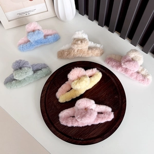 Collection of plush two-tone shark hair clips in assorted colors on wooden tray