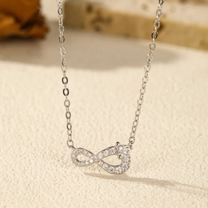 S925 sterling silver infinity pendant necklace with sparkling cubic zirconia on a beige background