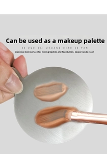 Macro detail of a round stainless steel palette with finger hole for mixing foundation and cream