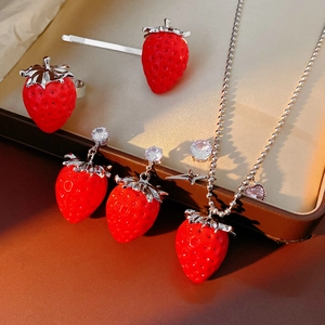 Dettaglio di un set di gioielli a fragola rossa con zirconi in una scatola