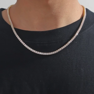 Close-up of gold hip-hop tennis necklace with square zircons on a black t-shirt