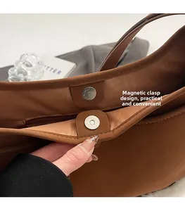 Detail view of large brown bucket bag featuring internal magnetic clasp design and lining