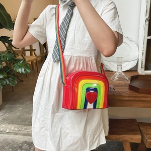 Detailed shot of rainbow crossbody bag with red heart patch and adjustable webbing strap