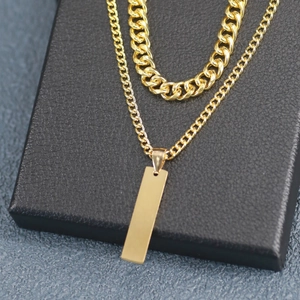Close-up of gold layered Cuban chain necklace set with rectangular pendant on black box