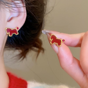Close-up of red horse stud earrings with gold plating and zircon details on model