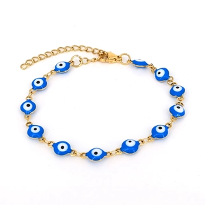 Detail of gold chain bracelet with blue evil eye enamel beads on white background