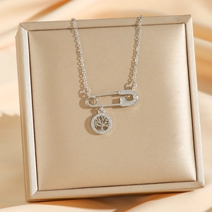 Collier avec épingle d'arbre plaqué or 18k et diamants sur fond satiné élégant