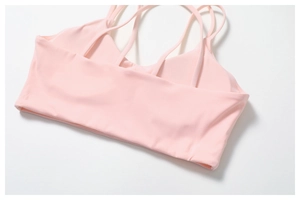 Détail du soutien-gorge de yoga rose clair avec plusieurs bretelles croisées dans le dos