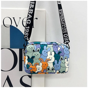 Detail of cartoon rabbit print small crossbody bag with branded wide woven shoulder strap