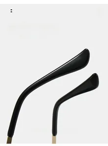 Nahaufnahme der geschwungenen Harzbügel und Goldmetallscharniere der randlosen Brille