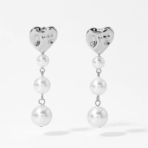Detail showing heart-shaped silver metallic texture and cascading pearl tassel earrings