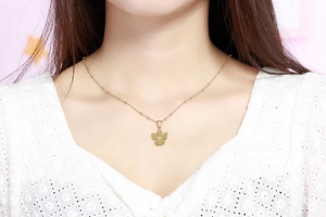 Dettaglio della collana con ciondolo angelo dorato e lettera Y indossata da una modella