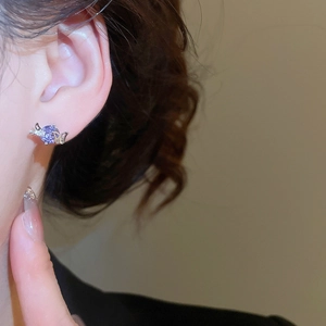 Detailansicht eines eleganten violetten Kristall Schmetterling Ohrrings am Ohr