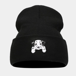 Close-up of a black knitted beanie featuring a detailed dalmatian dog head embroidery
