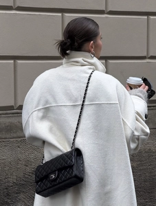 Rear view of elegant white wool coat with oversized collar and thick texture