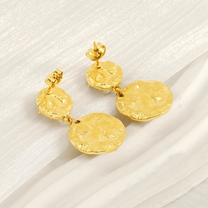 Detailed macro view of golden starburst earrings with radial texture and stud butterfly back