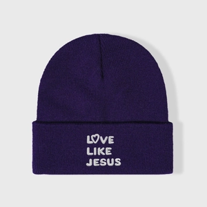 Purple knit beanie with Love Like Jesus embroidery and heart motif in a front flat lay view