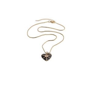 Détail du pendentif cœur en or avec émail noir, motifs en croix et zircons brillants