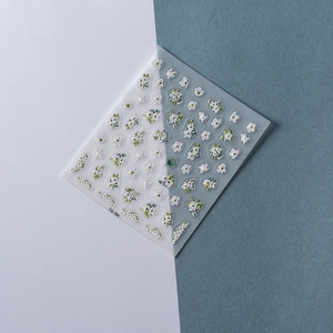 Detailed view of TS-184 embossed nail stickers with white flowers and green leaf designs